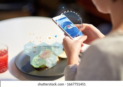 Food, New Nordic Cuisine, Technology And People Concept - Close Up Of Woman With Toast Skagen On Smartphone Screen And Nutritional Value Chart At Restaurant