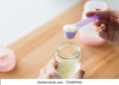 Food And Nutrition Concept - Mother Hands With Jar, Scoop And Baby Bottle Preparing Infant Formula Milk