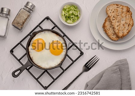 Food photography of breakfast, fried eggs, bread, toast, seasoning, salt, spring onion, frying pan, wooden, continental, background, homemade meal