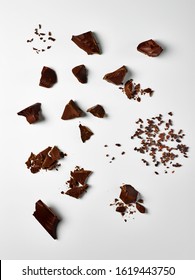 Food Photography Of Different Types Of Chocolate Chunks, Pieces And Cacao Nibs Shot Overhead On A White Background