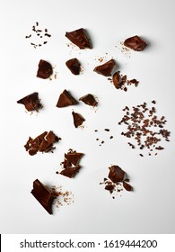 Food Photography Of Different Types Of Chocolate Chunks, Pieces And Cacao Nibs Shot Overhead On A White Background