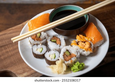 Food photography styling presentation. Close up isolated white plate, wooden board, chopsticks. Sushi roll, raw salmon, nori seaweed wrap, spicy mayo, wasabi, pickled ginger. Delicious healthy Asian. - Powered by Shutterstock