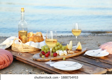 Food For Picnic And White Wine Served On Wooden Pallet Near River