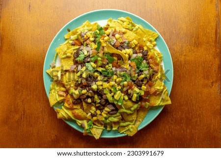 food plate of nachos with spices, corn, beans and avocado