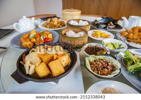 Food platter combo set of traditional Cantonese yum-cha dim sum Asian gourmet cuisine meal food dish on the round table includes dishes of duck, pork, fish, chicken, vegetables, tea, dumplings, buns