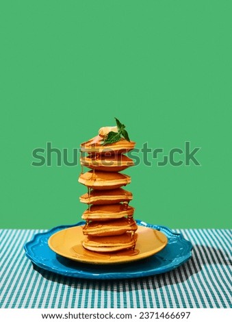 Food pop art photography. Delicious sweet pancakes with maple syrup and batter on plates over green background. Vintage, retro 80s, 70s style. Complementary colors. Concept of food, style, taste. Ad