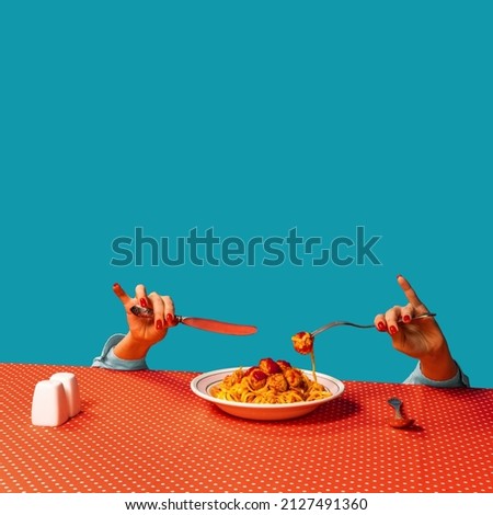Food pop art photography. Female hands tasting spaghetti with meatballs on plaid tablecloth isolated on bright blue background. Vintage, retro style interior. Complementary colors, Copy space for ad