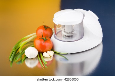 Food Processor With  Tomatoes, Onions And Garlic On Colorful  Background