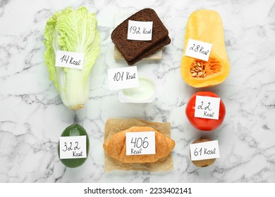 Food products with calorific value tags on white marble table, flat lay. Weight loss concept - Shutterstock ID 2233402141