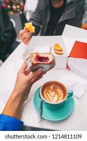 Food Selfie Girl Eating A Berry Filled Berliner Donut While Drinking A Cappuccino Coffee Cup At Cafe . City Urban Tourists Travel Lifestyle, POV Of Tourist Foodie Woman Holding Delicious Doughnut .