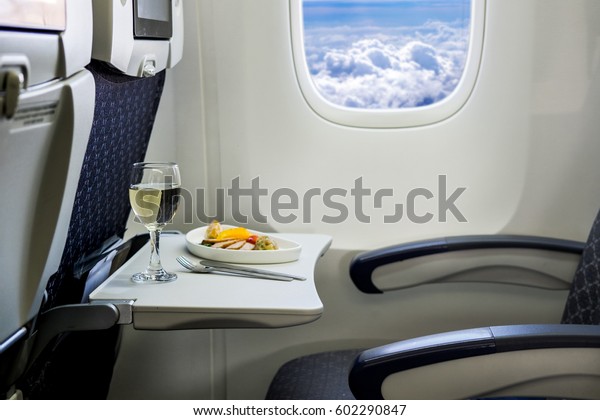 Food served on board of economy class airplane on\
the table.