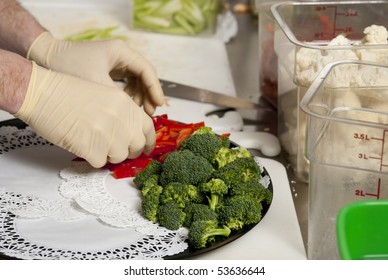 A Food Service Worker Places Broccoli On A Tray