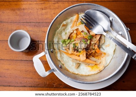 Food set of breakfast pan-fried egg with toppings sausage and vegetables on small pan at local restaurant cafe shop for thai people travelers customer use service eat drinks in Ratchaburi, Thailand