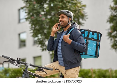 food shipping, profession and people concept - happy smiling delivery man with thermal insulated bag and bicycle on city street calling on smartphone - Powered by Shutterstock