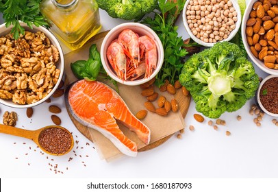 Food Sources Of Omega 3 And Omega 6 On White Background Top View. Foods High In Fatty Acids Including Vegetables, Seafood, Nut And Seeds