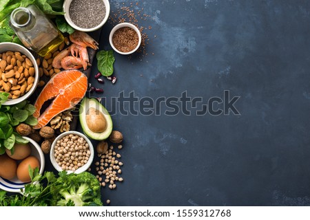 Food sources of omega 3 and healthy fats on dark background top view. Copy Space. Vegetables, seafood, nut and seed