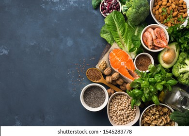 Lebensmittelquellen von Omega 3 auf dunklem Hintergrund mit Kopienraum-Draufsicht. Lebensmittel mit hohem Gehalt an Fettsäuren, einschließlich Gemüse, Meeresfrüchten, Nüssen und Samen. Fitness im Gesundheitswesen