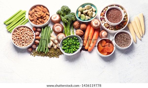 Food sources of plant based protein. Healthy diet\
with  legumes, dried fruit, seeds, nuts and vegetables.  Foods high\
in protein, antioxidants, vitamins and fiber. Image with copy\
space. Top view