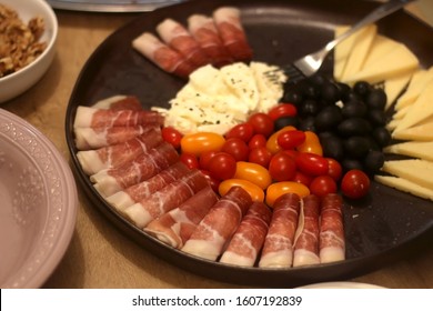 Food Spread With Prosciutto, Various Cheese, Tomatoes And Olives. Selective Focus.