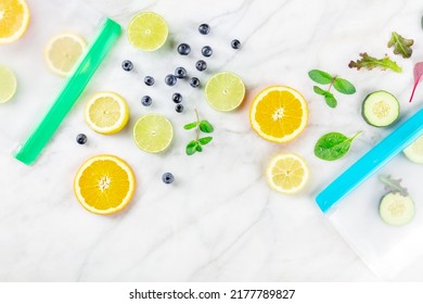 Food Storage Bags With Fruit And Vegetables, Overhead Flat Lay Shot On A White Marble Kitchen Table. Fresh Summer Produce In Ziplock Containers, Ready For The Fridge Or Freezer