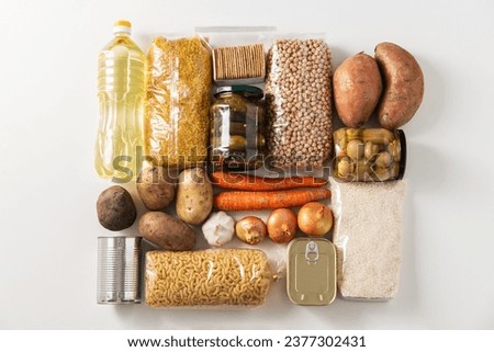 food storage and eating concept - close up of different cereals, groceries and preserves on white background, top view