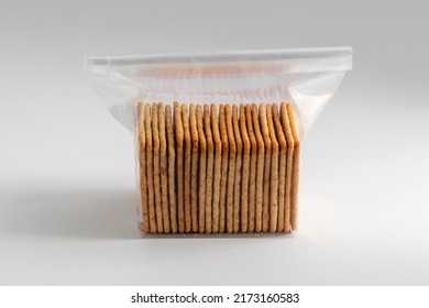 Food Storage, Eating And Snacks Concept - Close Up Of Salted Cookies Or Crackers In Plastic Bag On White Background