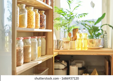 Food Storage At Home, Sunflower Oil On Table In Pantry. Pantry Interior, Wooden Shelf With Food Cans And Kitchen Utensils