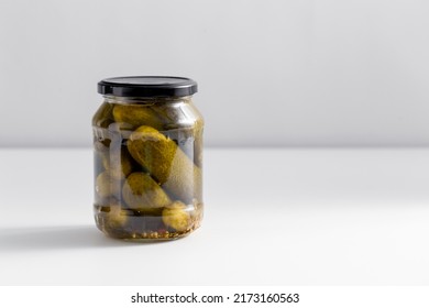 Food, Storage And Preserve Concept - Close Up Of Jar With Pickled Cucumbers On White Table