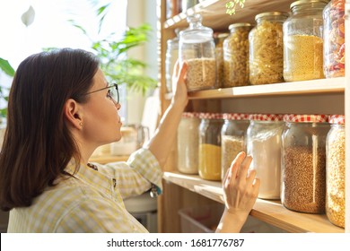 Food Storage, Wooden Shelf In Pantry With Grain Products In Storage Jars. Woman Taking Food For Cooking