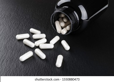 food supplement capsules on black background closeup