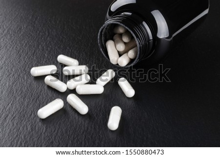 food supplement capsules on black background closeup