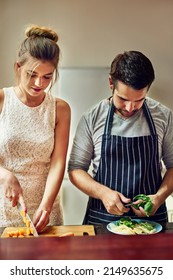 Food Tastes Better When We Cook Together. Shot Of A Young Couple Preparing Food Together At Home.