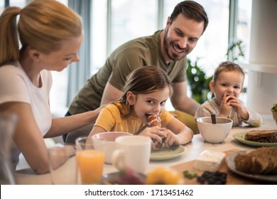 Food Tastes Better When You Eat It With Parents. Family In Kitchen Eating Together. Focus Is On Background.