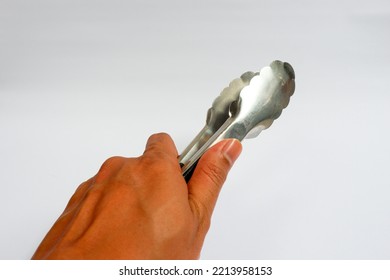 Food Tongs Holding By Left Hand Isolated In White Background