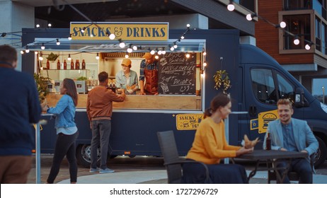 Food Truck Employee Hands Out a Card Card Terminal For Contactless Payment to Happy Young Hipster Customer, who is Buying a Tasty Burger. Commercial Truck Selling Street Food in Cool Neighbourhood. - Powered by Shutterstock