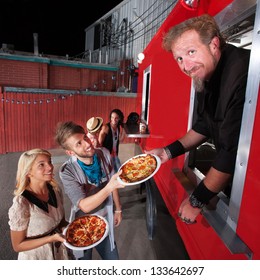 Food Truck Owner Serving Pizza To Happy Couple