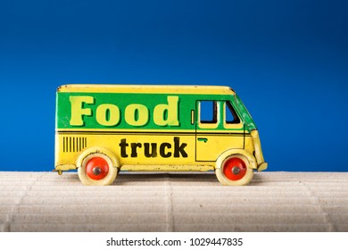 Food Truck, Vintage Tin Toy Van On Blue Background.