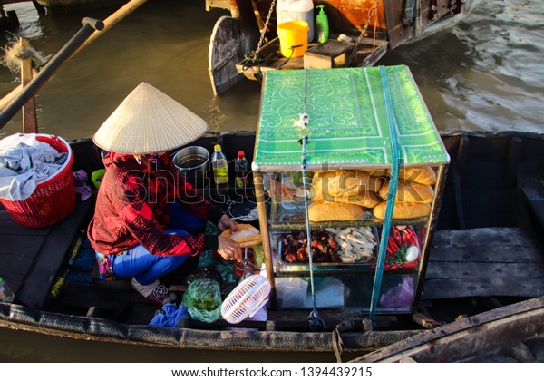 A food vendor selling\
banh mi on a sampan (wooden boats) at Cai rang Floating Market in\
Can tho, Vietnam