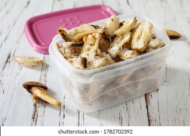 Food for the winter. Frozen vegetables. Container with frozen mushrooms. - Powered by Shutterstock