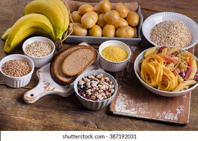 Foods high in carbohydrate on rustic wooden background. Top view