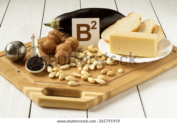Foods rich in vitamin B2: eggplant, cheese, white bread, walnuts, almonds, tea on a cutting board