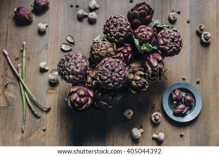 Foodstyle. Artichoke. Artwork. Mushrooms. On a wooden table there is a metal plate, which lie artichokes. Nearby are the mushrooms, asparagus, capers, a piece of rope and a large sea salt Stock photo © 