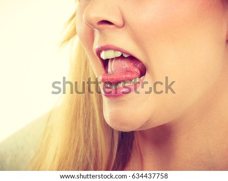 Fooling around, making silly faces concept. Blonde woman having tongue in clothespin