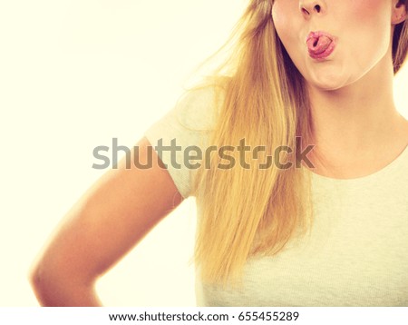 Fooling around, making silly faces concept. Blonde woman having tongue in clothespin