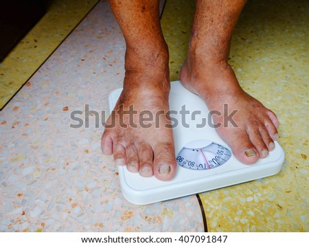 Foot Of Aged Man Standing On Weight Scale Foot Of Aged Man Standing On Weight Scale