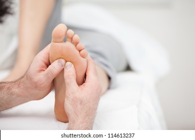 Foot Being Massaged On A Medical Table In A Room