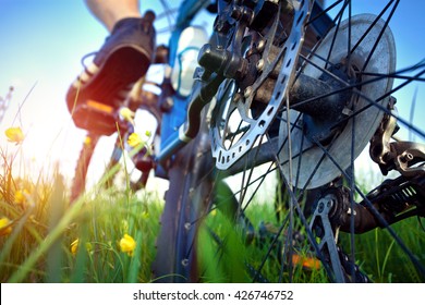 Foot of bicyclist on the pedal in the grass. Close up of the brakes. - Powered by Shutterstock