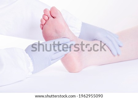 Foot doctor examining bare feet