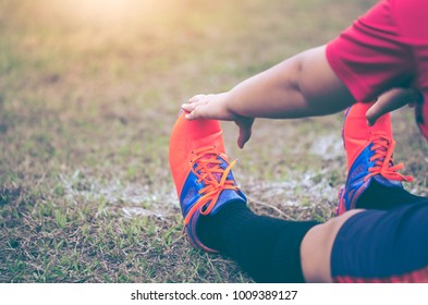 The foot of football players wearing orange football kicking shoes warm up ready to race. - Powered by Shutterstock