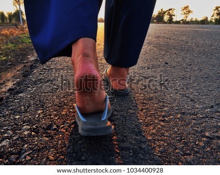 Foot of a girl walking on the road